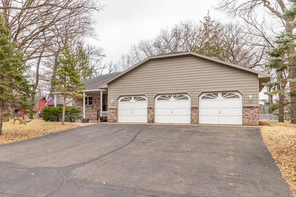 5439 264th St, Wyoming, MN 55092 - view of front of home featuring driveway, a garage, and brick siding