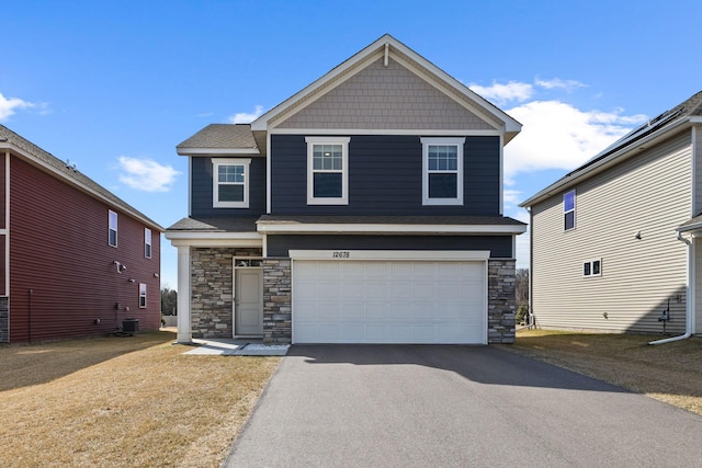 12678 Erskin St NE, Blaine, MN 55449 - craftsman-style home with stone siding, an attached garage, and driveway