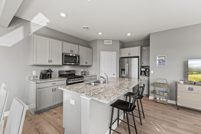 12678 Erskin St NE, Blaine, MN 55449 - kitchen with stainless steel appliances, a sink, light wood-type flooring, baseboards, and recessed lighting