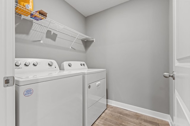 12678 Erskin St NE, Blaine, MN 55449 - laundry area with washing machine and clothes dryer, light wood-style flooring, and baseboards
