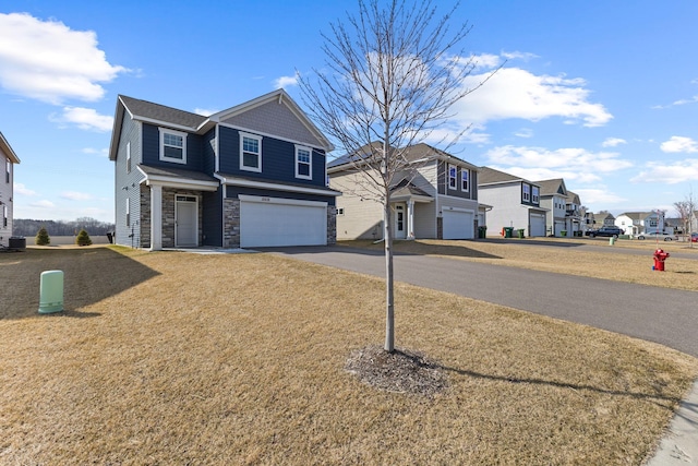 12678 Erskin St NE, Blaine, MN 55449 - view of front of property featuring a garage, stone siding, driveway, a residential view, and a front yard