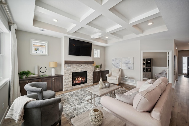 19995 Hunters Rdg, Corcoran, MN 55374 - living area featuring coffered ceiling, wood finished floors, beam ceiling, recessed lighting, and a stone fireplace