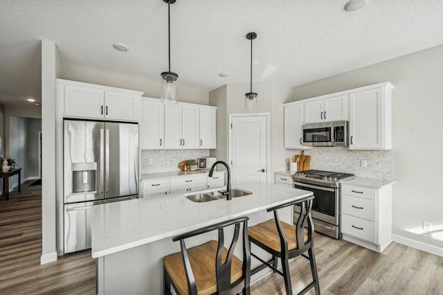 19993 Hunters Rdg, Corcoran, MN 55374 - kitchen with light wood finished floors, stainless steel appliances, decorative backsplash, and a sink