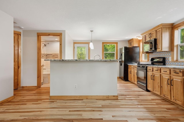4963 Crofoot Ave NW, Buffalo, MN 55313 - kitchen featuring black appliances, light wood finished floors, backsplash, and a center island