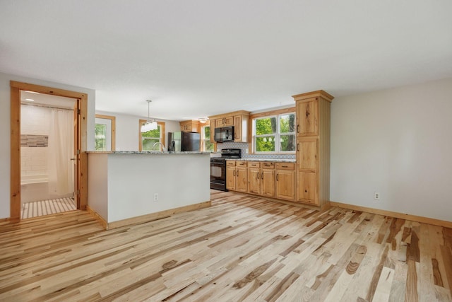 4963 Crofoot Ave NW, Buffalo, MN 55313 - kitchen with black appliances, plenty of natural light, light wood-style flooring, and a peninsula