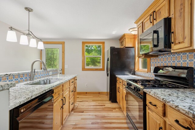 4963 Crofoot Ave NW, Buffalo, MN 55313 - kitchen featuring black appliances, light wood-type flooring, tasteful backsplash, light stone counters, and pendant lighting