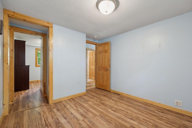 4963 Crofoot Ave NW, Buffalo, MN 55313 - unfurnished bedroom with light wood-type flooring and a textured ceiling