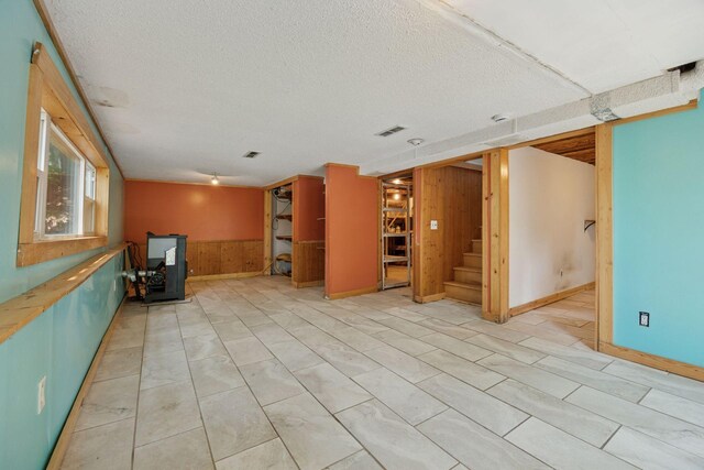 4963 Crofoot Ave NW, Buffalo, MN 55313 - unfurnished living room with wooden walls, stairs, wainscoting, and a textured ceiling