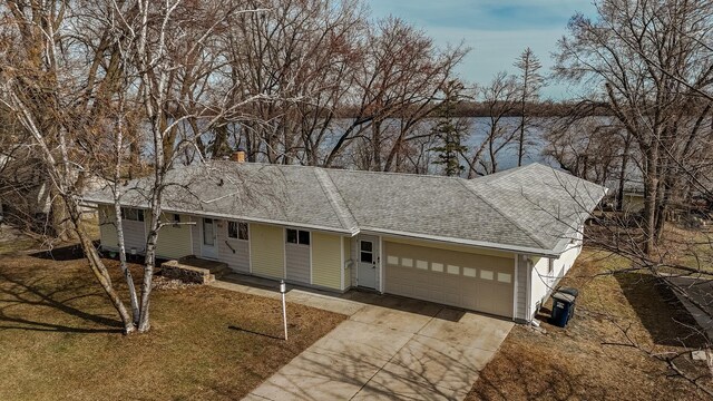 single story home with driveway, a shingled roof, a garage, and a front lawn