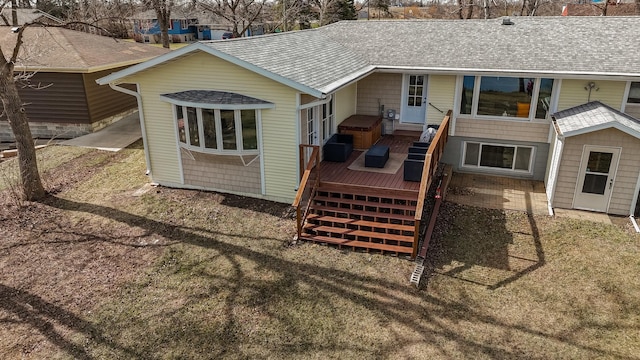 back of property with a deck and a shingled roof
