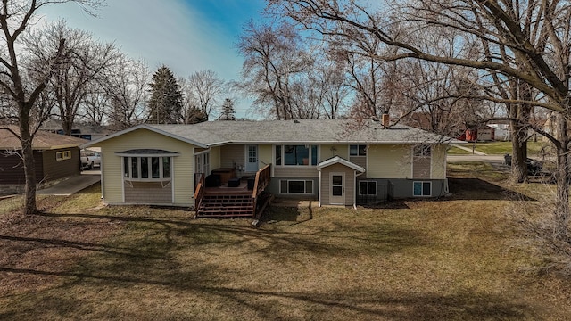 rear view of property with a wooden deck and a lawn