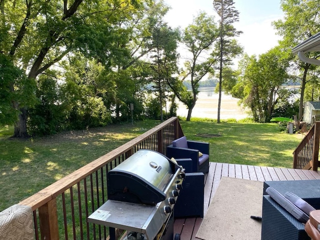 wooden deck featuring area for grilling and a lawn