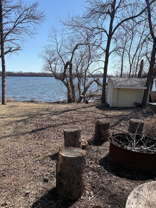 exterior space featuring a storage shed, an outdoor structure, and a water view