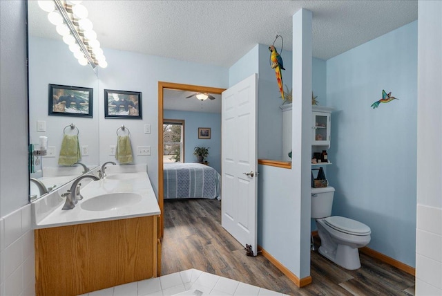 68 Crown Pointe Curv, Hudson, WI 54016 - bathroom with a sink, toilet, double vanity, ensuite bath, and wood finished floors