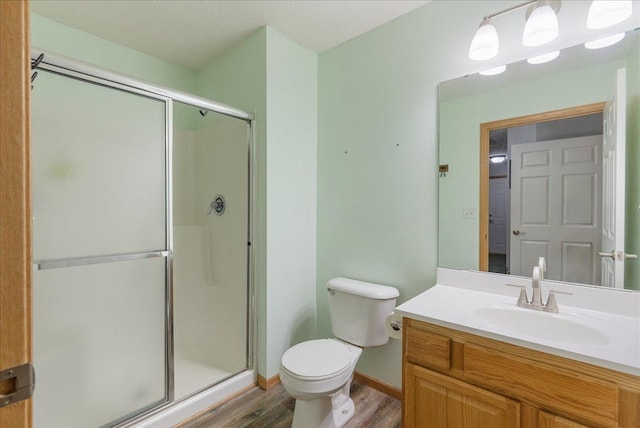 68 Crown Pointe Curv, Hudson, WI 54016 - full bathroom featuring vanity, baseboards, toilet, a shower stall, and wood finished floors
