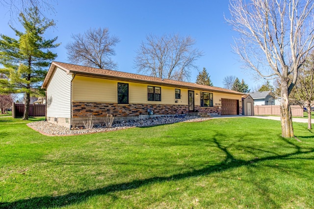 ranch-style home featuring fence, an attached garage, driveway, and a front yard