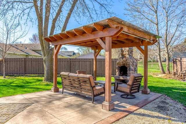 view of patio / terrace with an outdoor stone fireplace and a fenced backyard