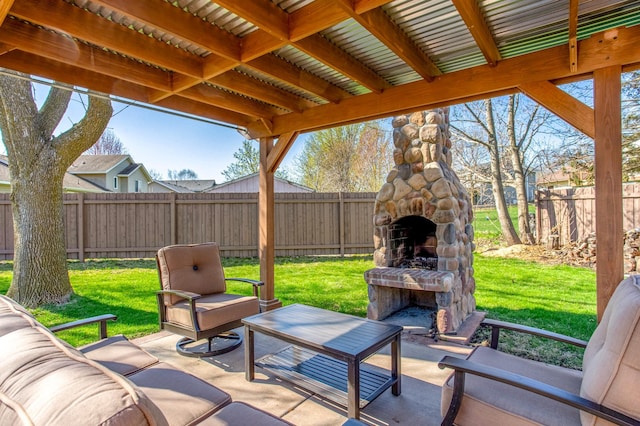 view of patio featuring an outdoor stone fireplace and a fenced backyard