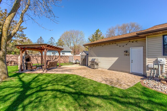 view of yard featuring a storage shed, a pergola, a fenced backyard, and a patio area