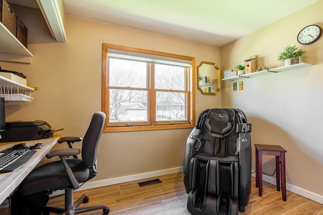 home office featuring baseboards, visible vents, and light wood-style floors