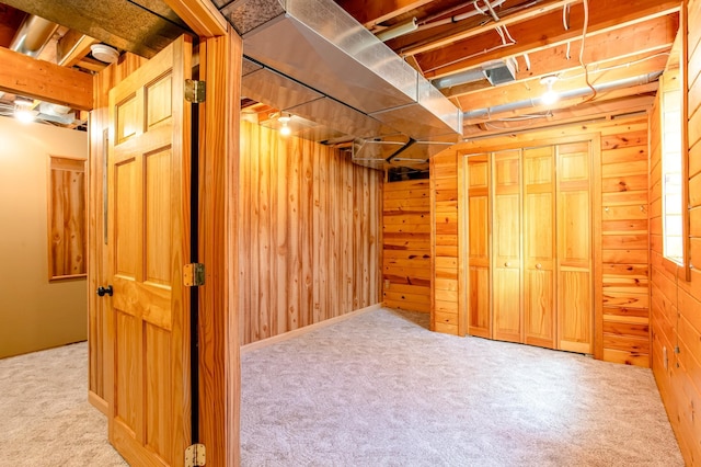 unfinished below grade area featuring carpet flooring and wood walls