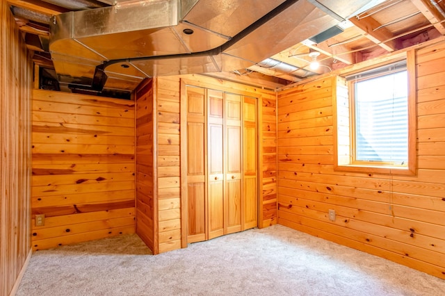 below grade area featuring carpet flooring and wood walls