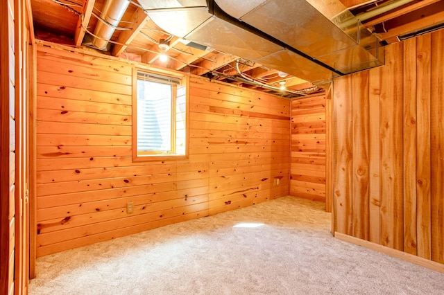 basement featuring wooden walls and carpet flooring