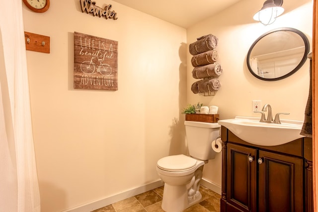 bathroom with toilet, baseboards, and vanity