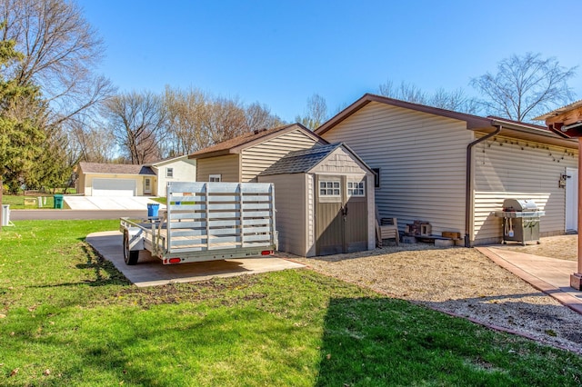 back of property featuring a lawn, an outdoor structure, and a storage unit
