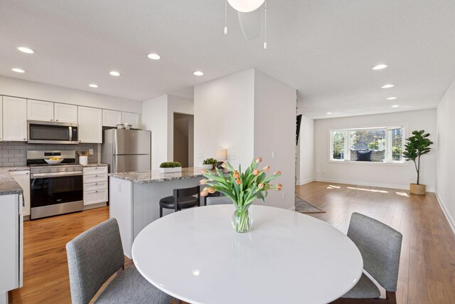 dining area featuring recessed lighting, light wood-style flooring, baseboards, and ceiling fan