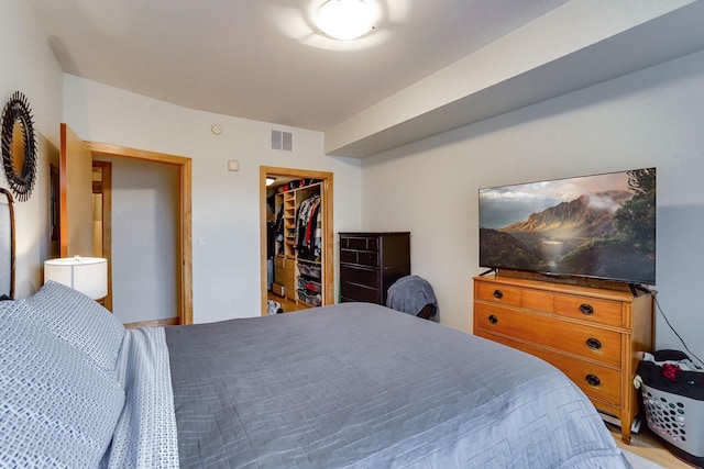 bedroom with a walk in closet, visible vents, and a closet