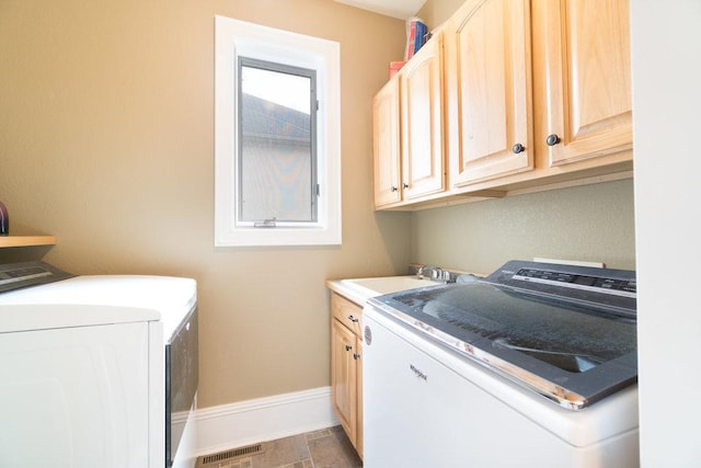 laundry room featuring a sink, visible vents, baseboards, separate washer and dryer, and cabinet space