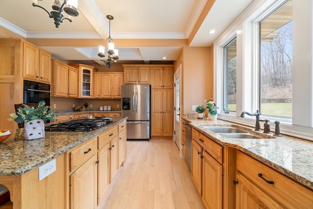 kitchen with black oven, a notable chandelier, stainless steel fridge, and a sink