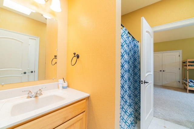 full bathroom featuring tile patterned floors, a shower with curtain, a textured wall, and vanity