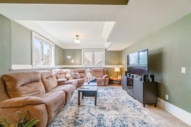 carpeted living area featuring baseboards and a textured wall