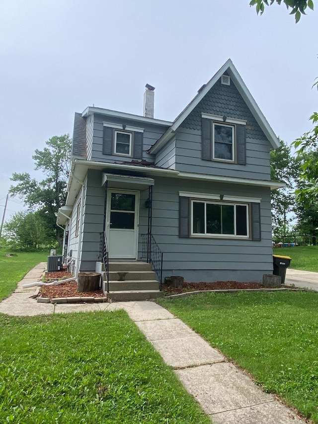 104 3rd St, Buffalo Lake, MN 55314 - view of front facade featuring entry steps, central air condition unit, a front lawn, and a chimney
