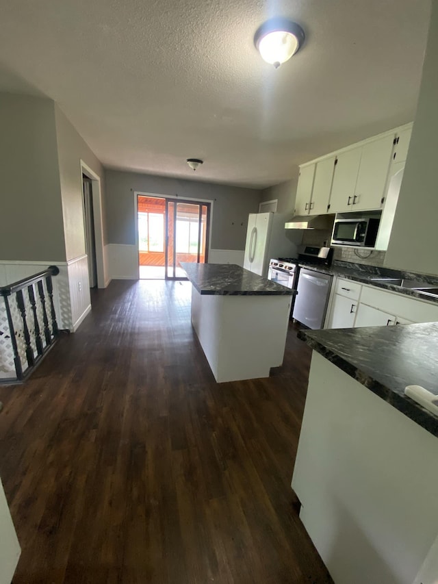 104 3rd St, Buffalo Lake, MN 55314 - kitchen featuring stainless steel appliances, dark countertops, a center island, dark wood finished floors, and a textured ceiling