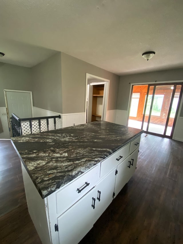 104 3rd St, Buffalo Lake, MN 55314 - kitchen with dark wood-type flooring, white cabinets, dark stone countertops, and a center island