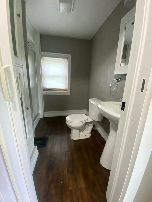 104 3rd St, Buffalo Lake, MN 55314 - half bathroom featuring wood finished floors, toilet, and baseboards