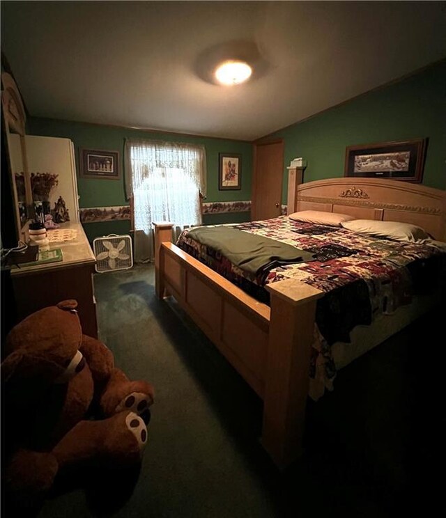bedroom with vaulted ceiling and dark carpet