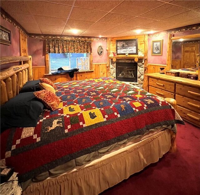 carpeted bedroom with wainscoting and wood walls