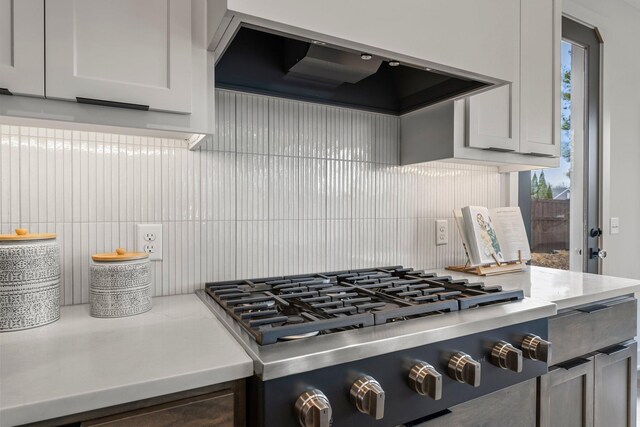 5012 Hankerson Ave, Edina, MN 55436 - kitchen view of exhaust hood, decorative backsplash, stainless steel gas cooktop, and light stone countertops