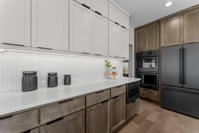 5012 Hankerson Ave, Edina, MN 55436 - kitchen featuring black appliances, light wood finished floors, decorative backsplash, light stone counters, and recessed lighting