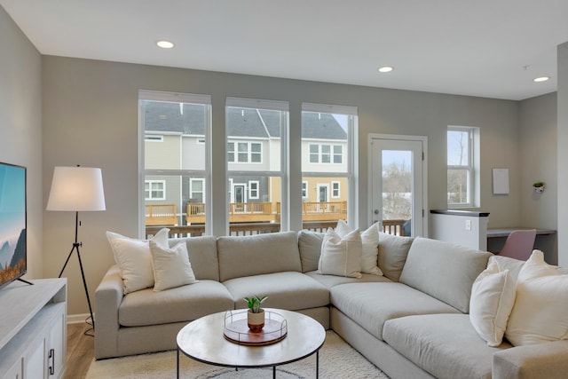 living room with recessed lighting, light wood-style flooring, and baseboards