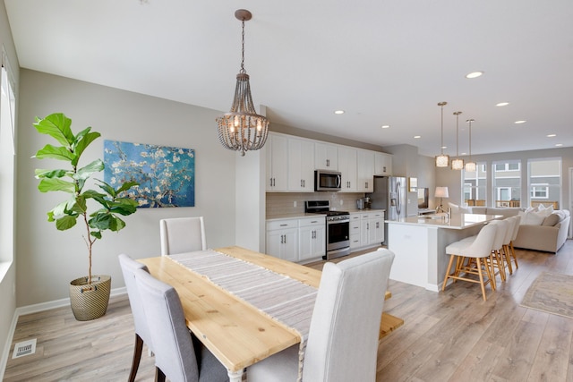dining area featuring light wood-style floors, an inviting chandelier, visible vents, and recessed lighting