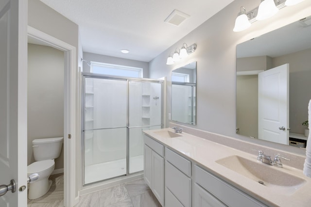 full bath featuring a shower stall, a sink, visible vents, and toilet