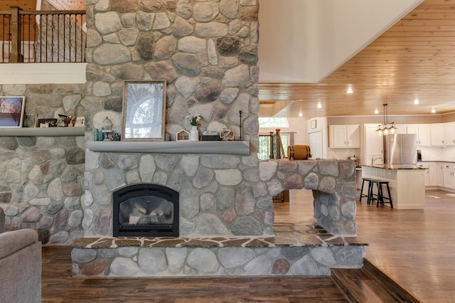 living area with wood finished floors, a stone fireplace, and healthy amount of natural light