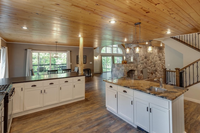 kitchen featuring a sink, gas range, open floor plan, wooden ceiling, and healthy amount of natural light
