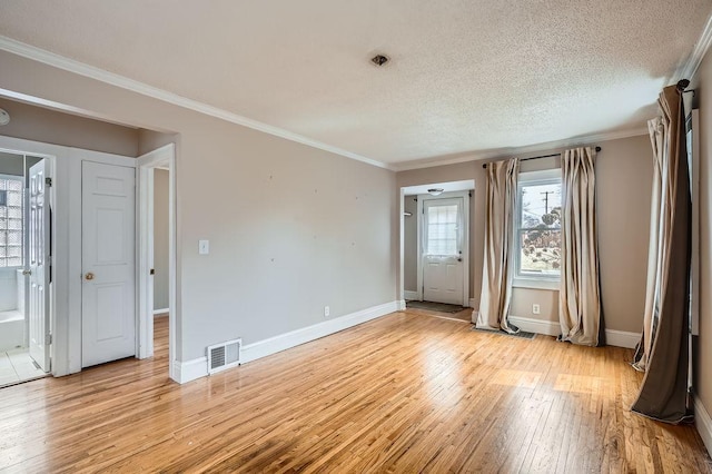 unfurnished bedroom featuring light wood-style flooring, baseboards, visible vents, and ornamental molding