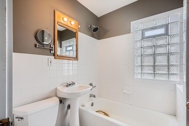 bathroom featuring toilet, tile walls, and shower / washtub combination